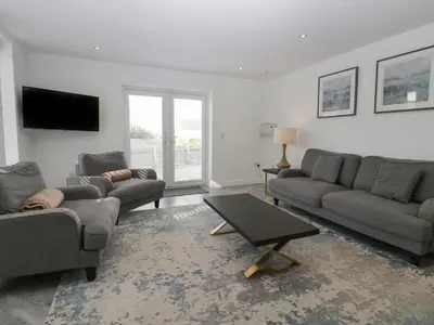 a living room with two couches and a tv at Edgemere Cottage in Grange Over Sands