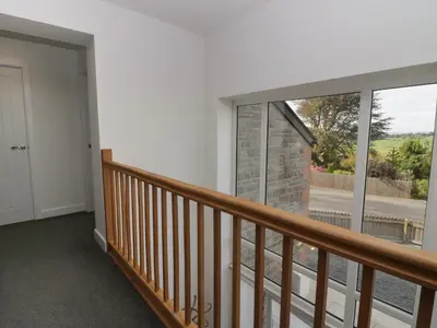 a room with a balcony with a large window at Edgemere Cottage in Grange Over Sands