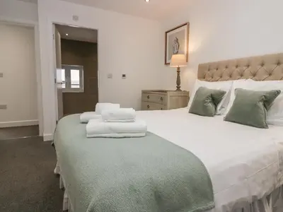 a bedroom with a large bed with two towels on it at Edgemere Cottage in Grange Over Sands