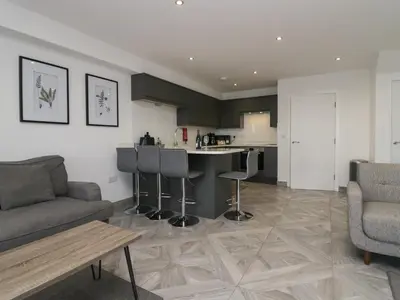 a living room with a couch and a kitchen at Edgemere Hideaway in Grange Over Sands