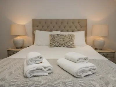 a bed with white towels on it with two lamps at Edgemere Retreat in Grange Over Sands