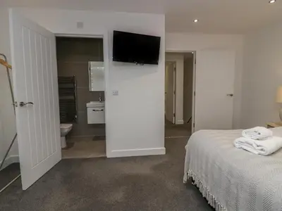 a bedroom with a bed and a tv on a wall at Edgemere Retreat in Grange Over Sands