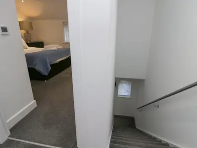 a hallway leading to a bedroom with a bed at Edgemere Retreat in Grange Over Sands
