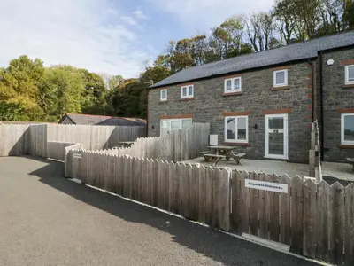 a wooden fence in front of a brick house at Edgemere Retreat in Grange Over Sands
