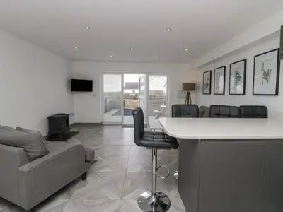 a living room with a couch and a table and chairs at Edgemere Retreat in Grange Over Sands
