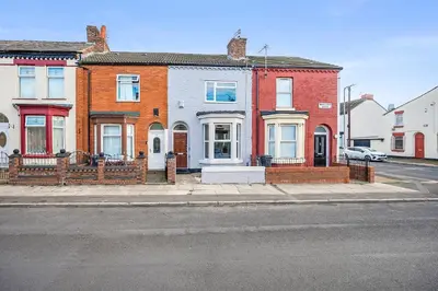 a row of brick houses on a city street at Miranda House - Air Host & Stay - Sleeps 7 in Liverpool