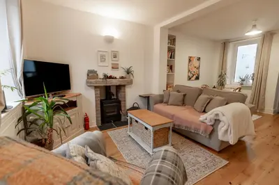 a living room with a couch and a fireplace at SUN COTTAGE - Cosy Cottage in Ulverston with a log burner in Ulverston, Cumbria in Ulverston