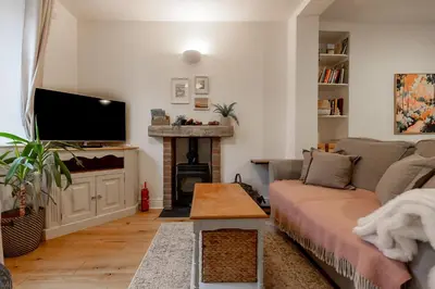 a living room with a couch and a fireplace at SUN COTTAGE - Cosy Cottage in Ulverston with a log burner in Ulverston, Cumbria in Ulverston