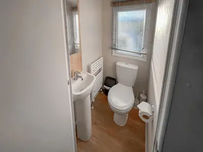 a small bathroom with a toilet and a sink at Edith Rose in Middleton