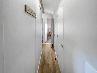 a hallway with white walls and a wooden floor at Edith Rose in Middleton
