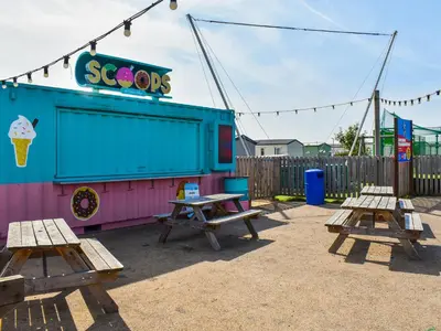 a playground with picnic tables and an ice cream shop at Edith Rose in Middleton