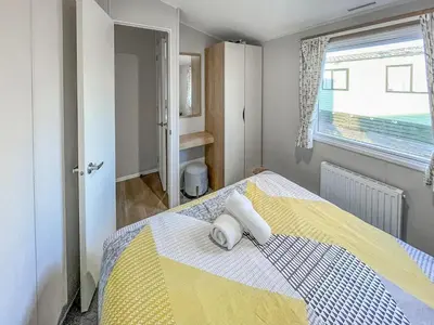 a bedroom with a yellow and white bed with a window at Edith Rose in Middleton
