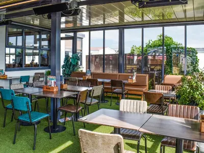 a restaurant with tables and chairs and windows at Marni's Seaview in Heysham