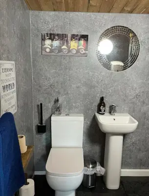 a bathroom with a white toilet and a sink at Fearless Fox Lodge in Altham