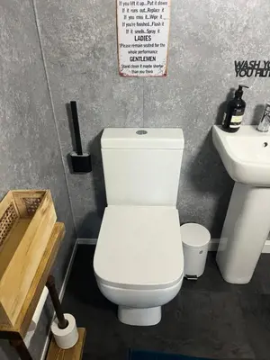 a bathroom with a white toilet and a sink at Fearless Fox Lodge in Altham