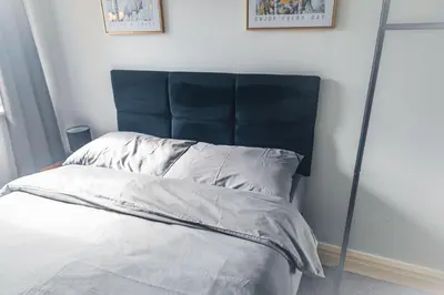 a bed with a blue headboard in a bedroom at Kos apartment 5 in Liverpool
