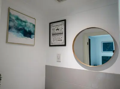 a bathroom with a round mirror on a wall at Kos apartment 5 in Liverpool