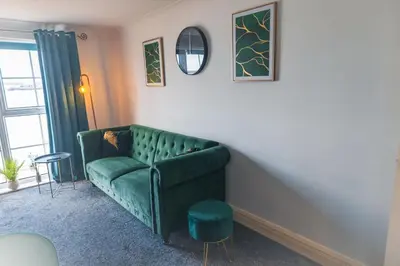 a green couch in a living room with a window at Kos apartment 5 in Liverpool