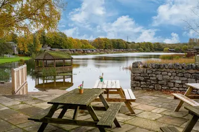 two picnic tables and a gazebo next to a river at Peaceful 3-Bed Lodge ! Ideal for Families! in Warton