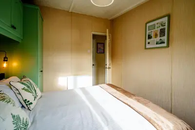 a bedroom with a white bed with a green wall at Peaceful 3-Bed Lodge ! Ideal for Families! in Warton