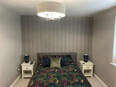 a bedroom with a bed with two night stands at Priory Gardens – Birkdale - 2 bed in Southport
