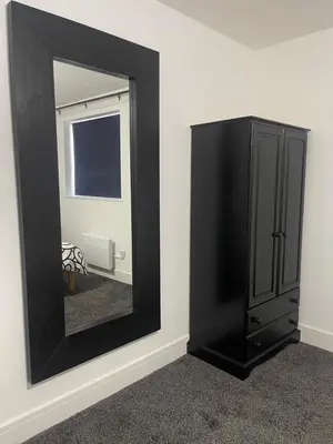 a black dresser and a mirror in a room at Bay Wind Deluxe in Morecambe