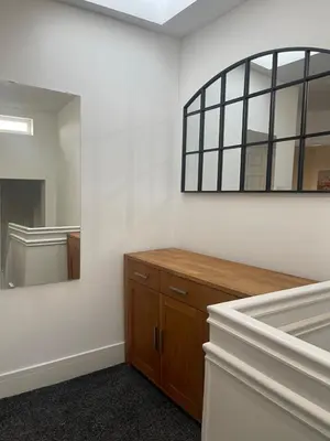 a bathroom with a mirror and a wooden dresser at Bay Wind Deluxe in Morecambe