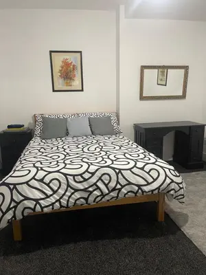 a bedroom with a bed with a black and white comforter at Bay Wind Deluxe in Morecambe