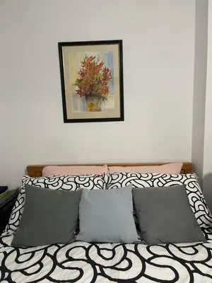 a bed with pillows and a picture on the wall at Bay Wind Deluxe in Morecambe