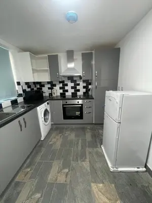 a kitchen with a white refrigerator and a dishwasher at Bay Wind Deluxe in Morecambe
