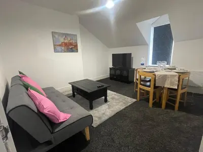 a living room with a couch and a table at Bay Wind Deluxe in Morecambe
