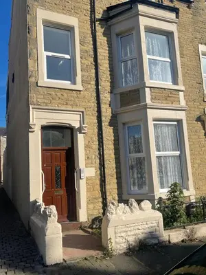 a brick house with a brown door and windows at Bay Wind Deluxe in Morecambe