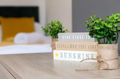 a sign on a table with two potted plants at Modern 5-Bedroom House with 8 Beds, Perfect for Contractors, Extended Stay Savings in Wallasey