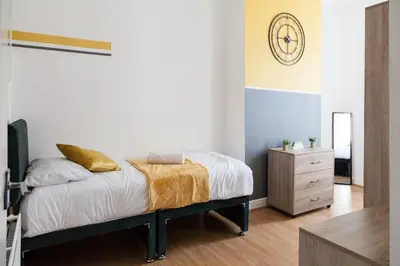 a bedroom with a bed and a dresser at Modern 5-Bedroom House with 8 Beds, Perfect for Contractors, Extended Stay Savings in Wallasey