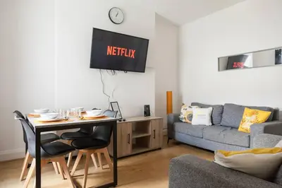 a living room with a table and a couch at Modern 5-Bedroom House with 8 Beds, Perfect for Contractors, Extended Stay Savings in Wallasey