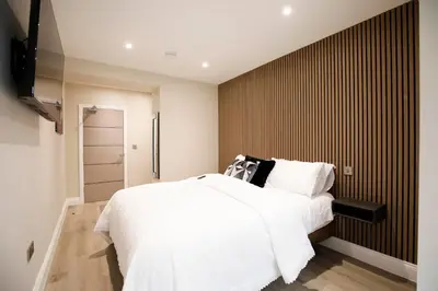 a bedroom with a white bed and a television at Oceania Suites in Blackpool