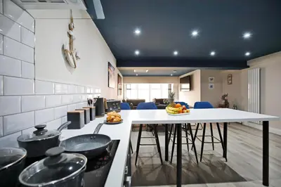 a kitchen with a table and chairs in a room at Oceania Suites in Blackpool