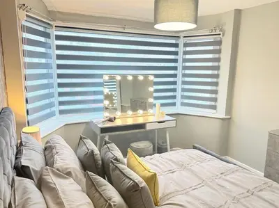 a living room with a couch in front of a mirror at GGs Holiday Let in Poulton le Fylde