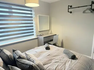 a bedroom with a bed and a desk and a mirror at GGs Holiday Let in Poulton le Fylde
