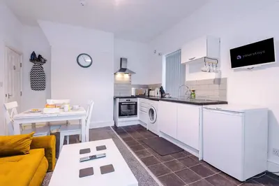a kitchen and living room with a couch and a table at St Paul's by YourStays - 1 Bedroom House in Merseyside in Seacombe