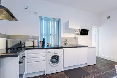 a white kitchen with a washing machine in it at St Paul's by YourStays - 1 Bedroom House in Merseyside in Seacombe