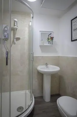a bathroom with a shower and a sink and a toilet at Beautiful & Spacious Suite in Blackpool Centre in Blackpool