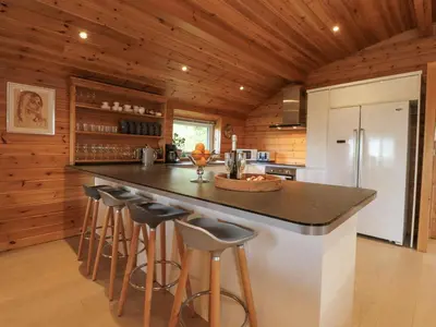 a kitchen with a counter and bar stools at Artisan Lodge in Preston