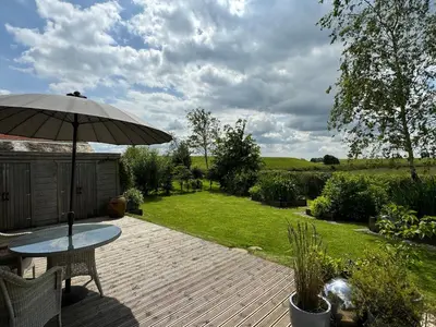 a wooden deck with a table and an umbrella at Artisan Lodge in Preston
