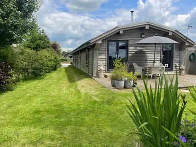 a wooden house with an umbrella in a yard at Artisan Lodge in Preston