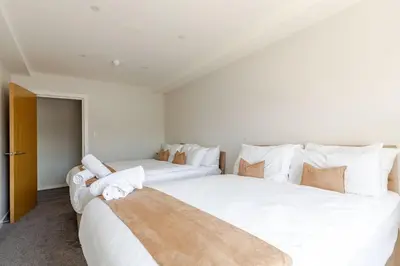 two beds in a bedroom with white sheets and pillows at Large 2-Bedroom Apartment, Liverpool City Centre - Sleeps up to 10 in Liverpool