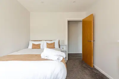 a bedroom with a large bed with white sheets and pillows at Large 2-Bedroom Apartment, Liverpool City Centre - Sleeps up to 10 in Liverpool