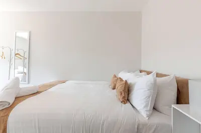 a white bedroom with a large bed with white pillows at Large 2-Bedroom Apartment, Liverpool City Centre - Sleeps up to 10 in Liverpool