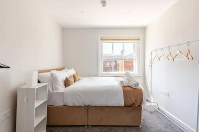 a bedroom with a large bed and a window at Large 2-Bedroom Apartment, Liverpool City Centre - Sleeps up to 10 in Liverpool