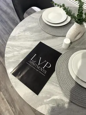 a table with white plates and a napkin on it at Large 2-Bedroom Apartment, Liverpool City Centre - Sleeps up to 10 in Liverpool